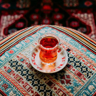 Tea on a cushion, on an afghan rug