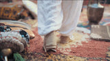 afghan man walking on a large afghan rug image