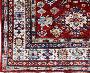 close up of hand knotted medium red white kazak afghan rug