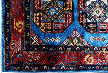 close up of hand knotted medium blue red kazak afghan rug