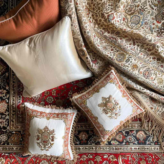 cushions and shawls on a luxury red afghan rug