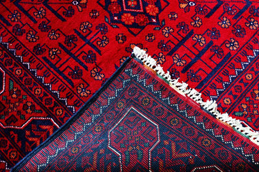 edge of a hand knotted small red khal mohammadi afghan rug